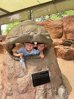 Two kindergarten students inside giant tortoise shell