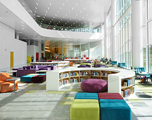 Large college library with colorful sitting areas near bookshelves