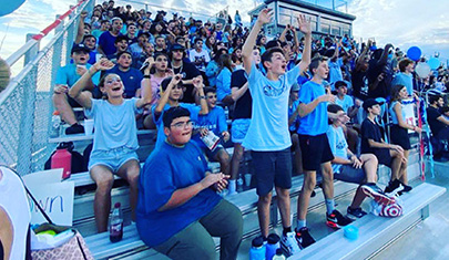 Students on bleachers cheering during activity