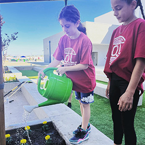 girls watering marigolds