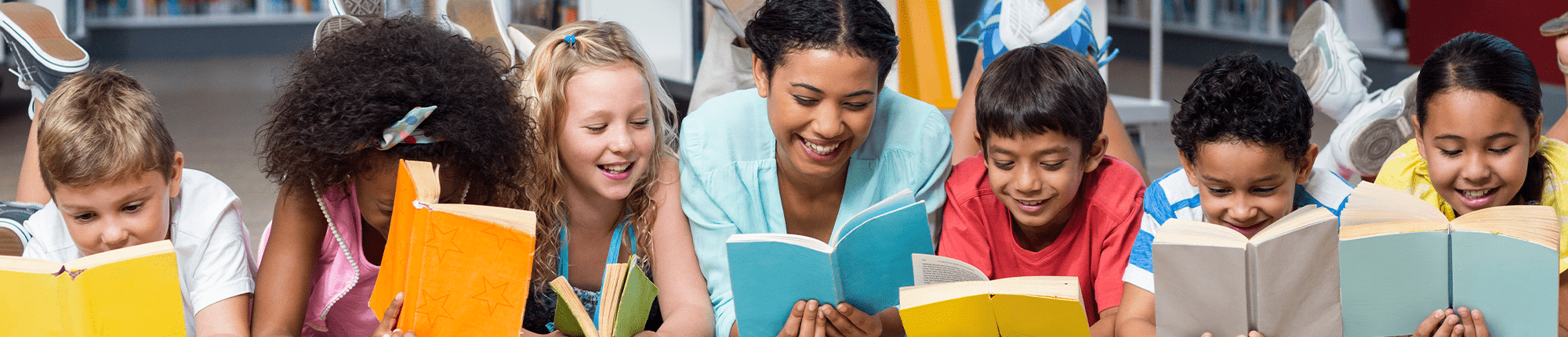 group of students laying on their stomach reading books