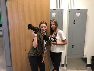 two students holding cameras