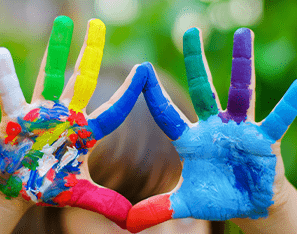 pair of hands covered in rainbow colored fingerpaints