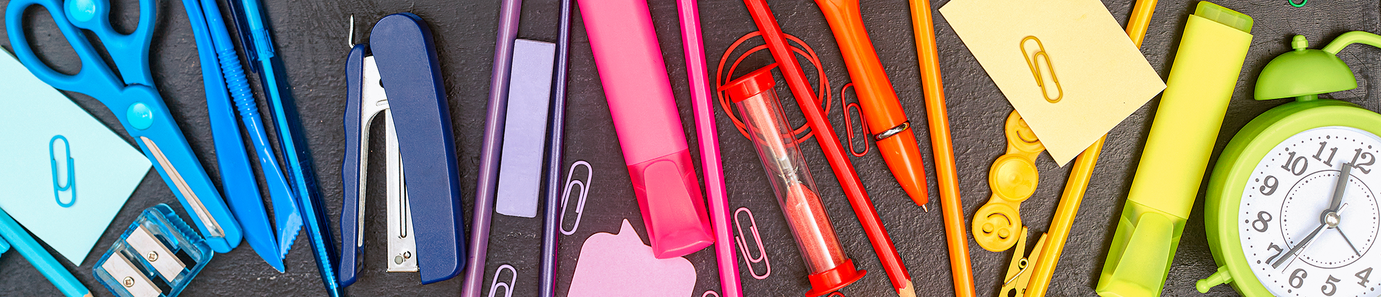 school supplies in rainbow colors on a desk