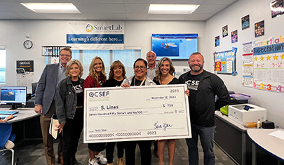Teachers holding a large check