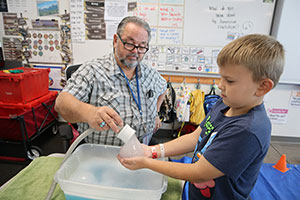 Teacher putting a big bubble into a student's hands