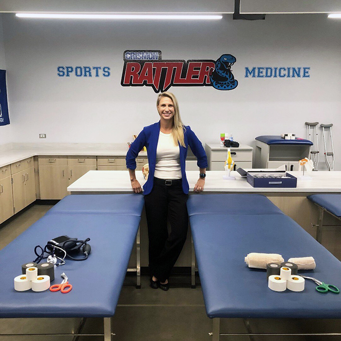 Woman smiling and standing in between beds in the Crismon Rattler sports medicine room