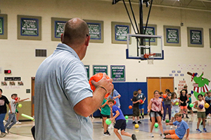 Adult preparing to toss dodgeball into the play area