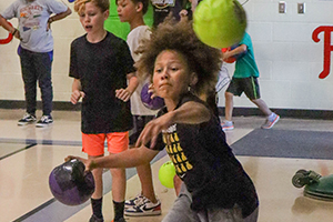 Student focused on tossing purple ball