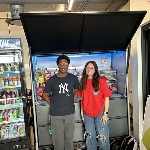 Two happy students in front of the Bird's Nest store