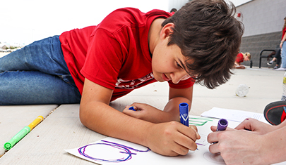 School boy drawing on the ground