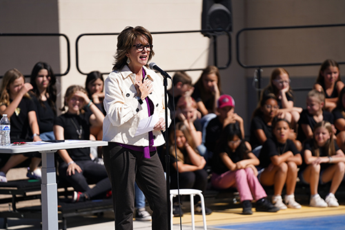 Woman talking into a microphone at outside event