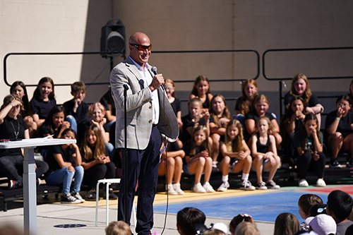 Man talking into a microphone at outside event