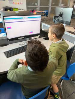 two boys working with computer