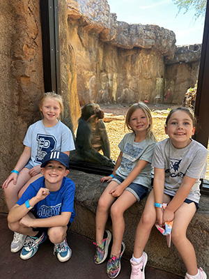 Four kindergarten students in front of orangutan enclosure
