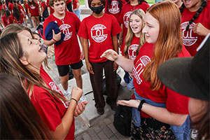 Students standing together playing rock paper scissors