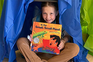 Girl inside a fort holding a book
