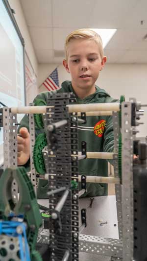 Student in classroom working with robotic