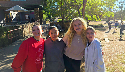 Four happy girls posing for a picture at science camp