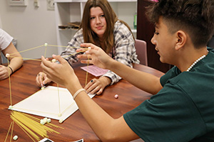 School kids building a model using spaghetti and sugar cubes