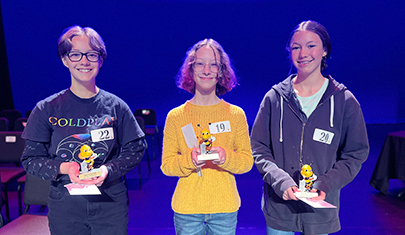 Three spelling bee participants on stage