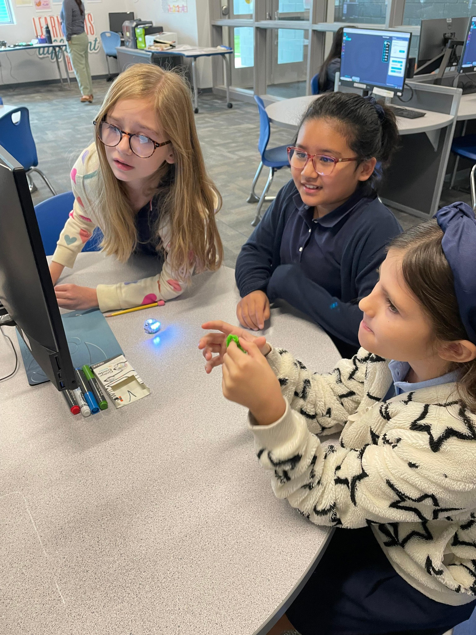 students around a table looking at the computer