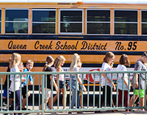 Students walking in a line next to school bus