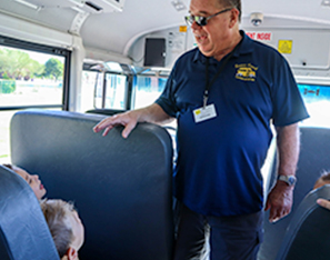 Staff worker inside bus talking to students