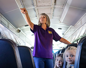 Female bus driver inside bus checking on students
