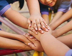 Students putting their hands together