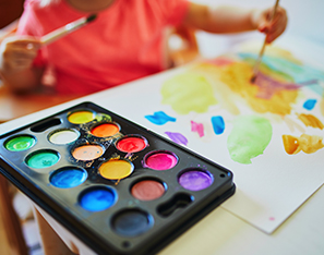 Kindergarten student painting with water colors