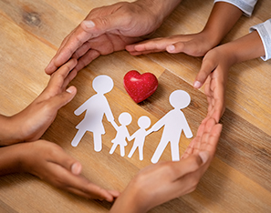 family hands around paper family and heart