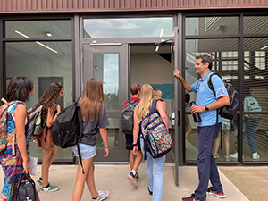 Principal welcoming students to school